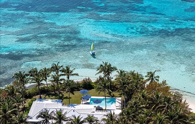 Lodge and pool over the reef with sailboat